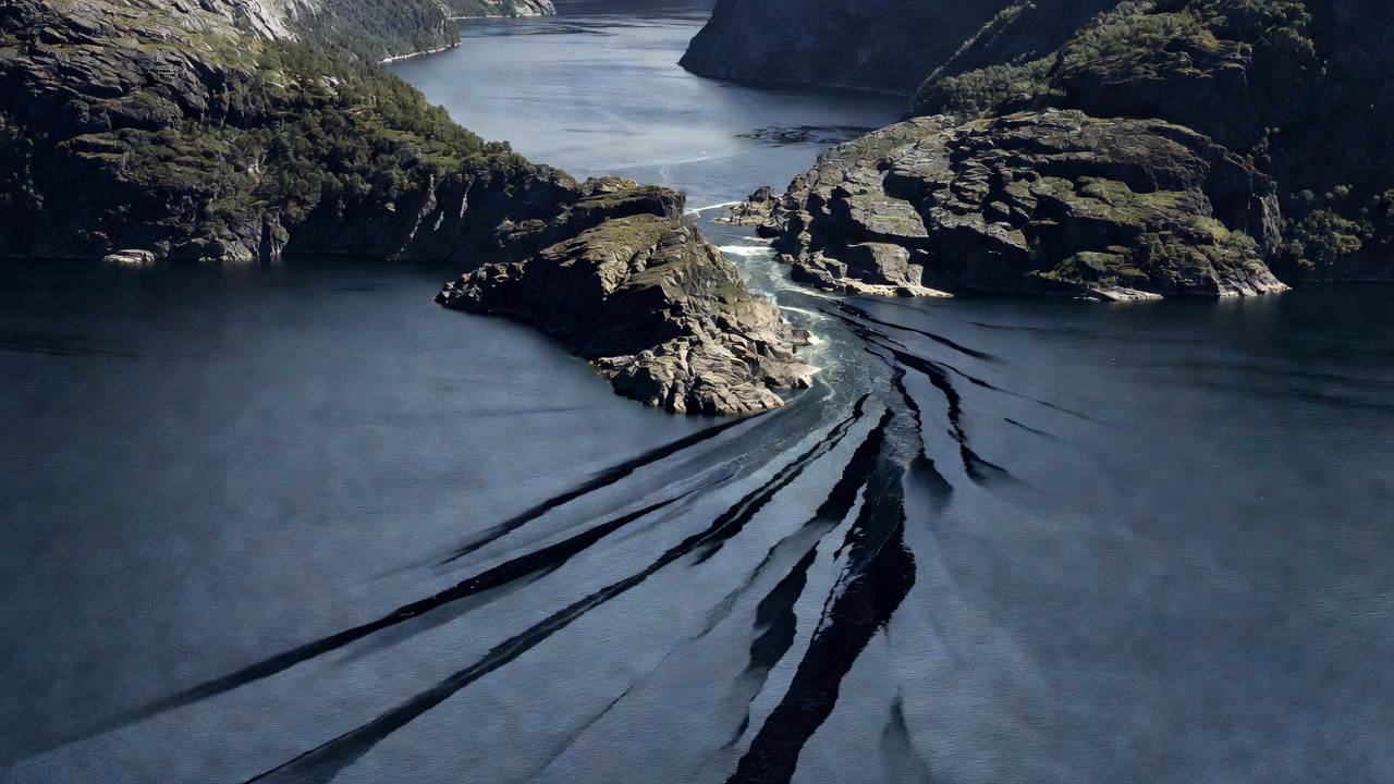 High-contrast view of two fjord branches meeting at a sharp rocky headland with dark wind streaks on the water
